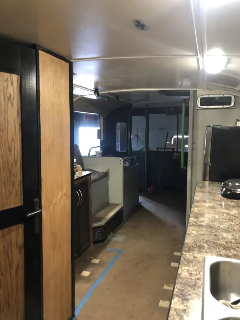 A kitchen with a refrigerator, sink and microwave.
