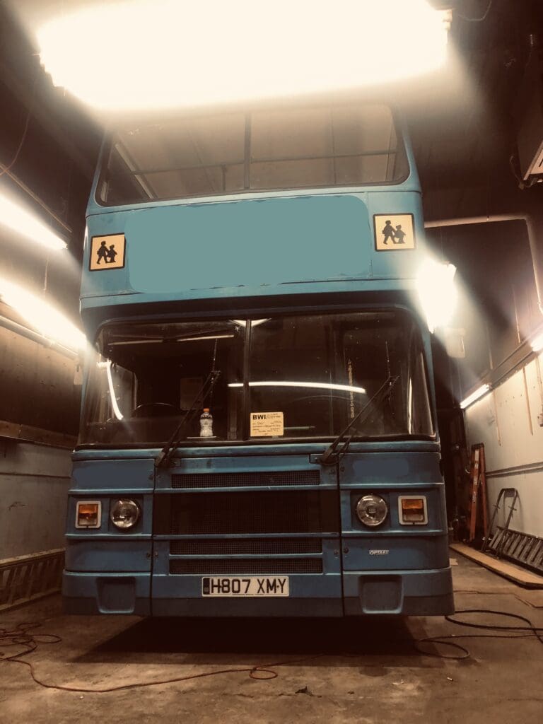 A double decker bus is parked in the tunnel.