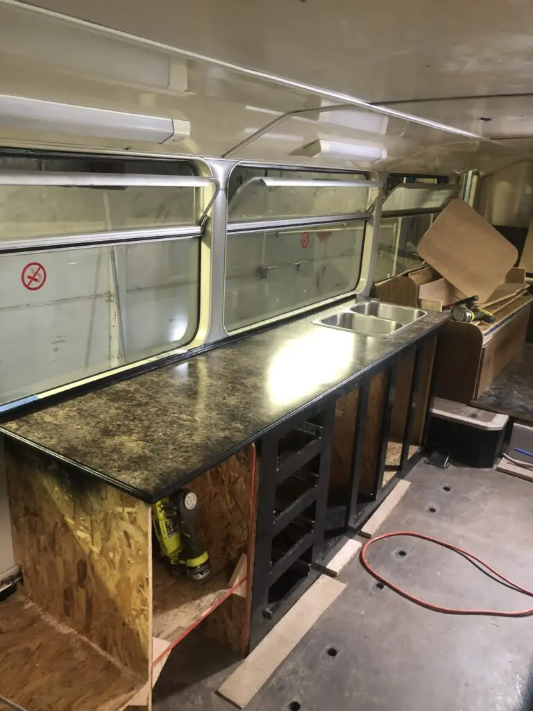 A kitchen area with counter and sink in it.