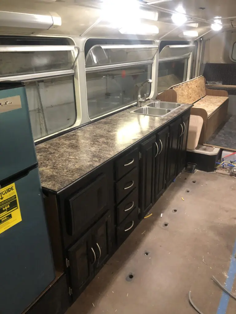 A kitchen with a sink and refrigerator in it