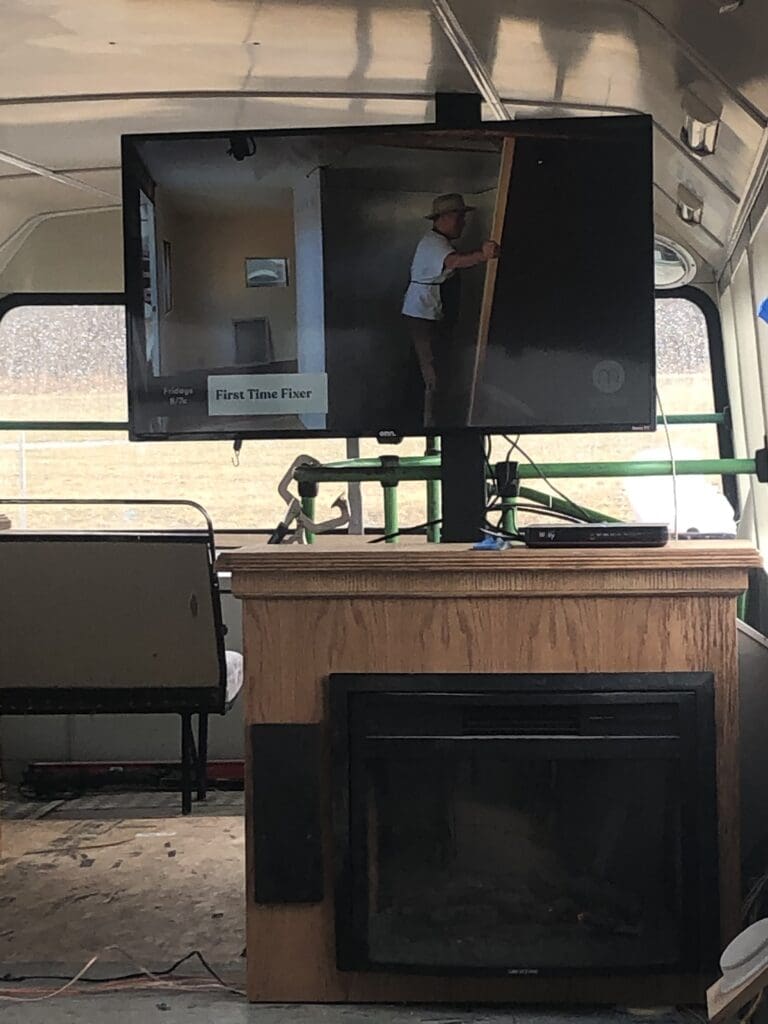 A tv mounted on the back of a bus.